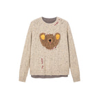 Teddy bear peeking through sweater