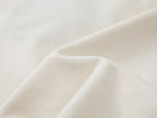 Teddy bear peeking through long-sleeve T-shirt