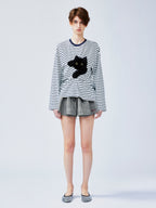 Playful cat scratching bedsheet striped T-shirt