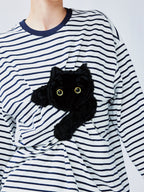 Playful cat scratching bedsheet striped T-shirt
