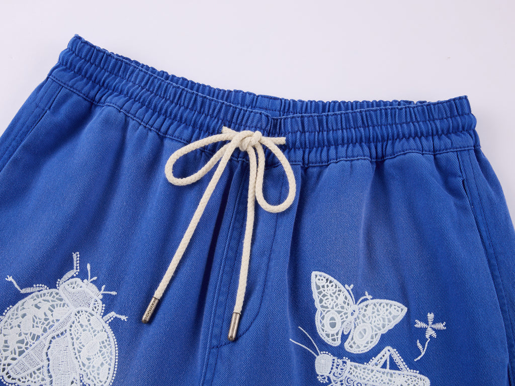 Lace insect and floral motif curved denim pants