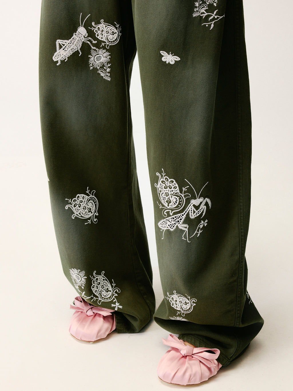 Lace insect and floral motif curved denim pants