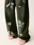 Lace insect and floral motif curved denim pants